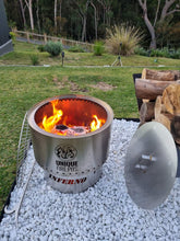 Load image into Gallery viewer, Fire pit with flames on a gravel surface in a garden setting, featuring 'Unique Fire Pits' branding.