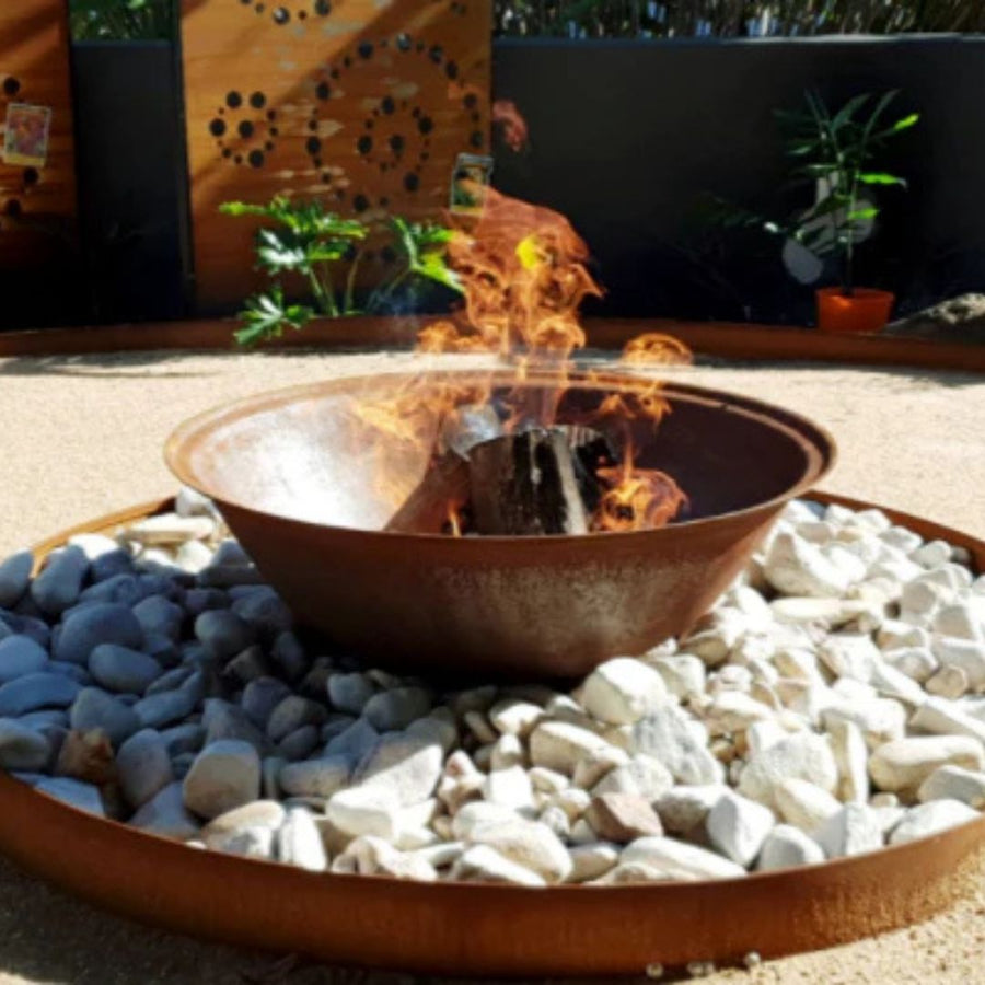Fire pit with flames surrounded by stones in an outdoor setting