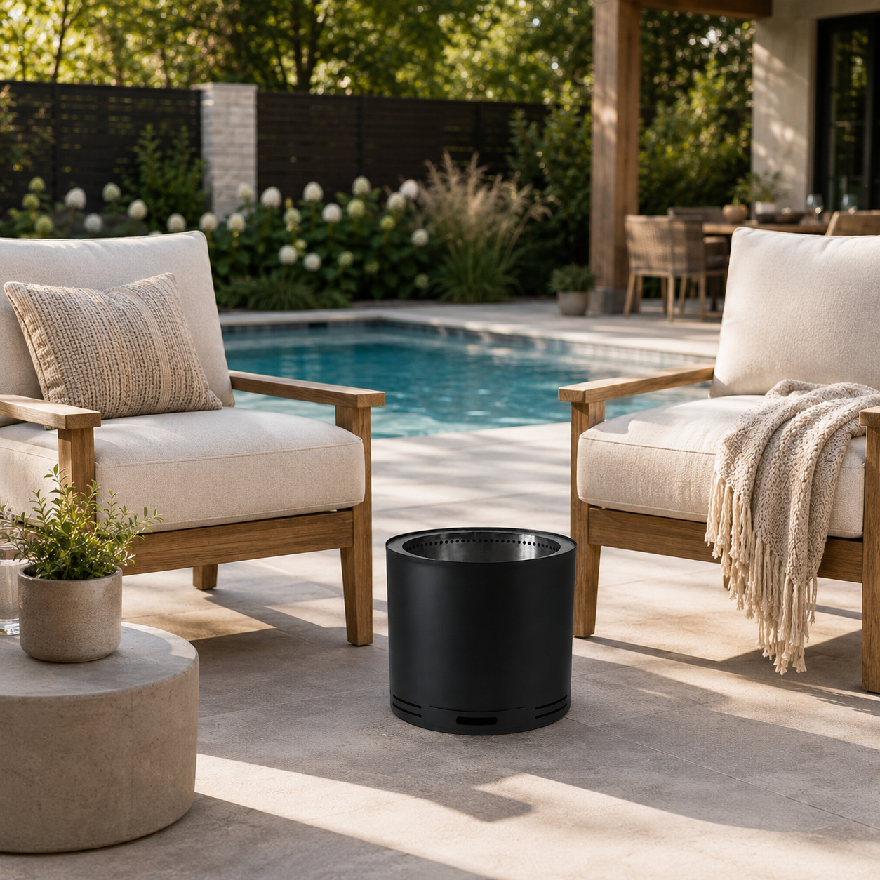 Outdoor patio with two chairs, The Onyx - Smokeless Fire Pit, and a pool in the background