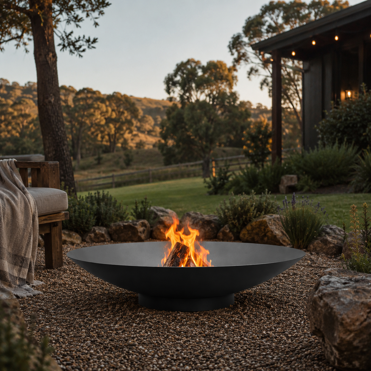 Outdoor setting with The Cauldron Black Fire Pit, bench, and scenic landscape.