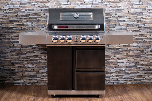Stainless steel BBQ with black accents against a stone wall background