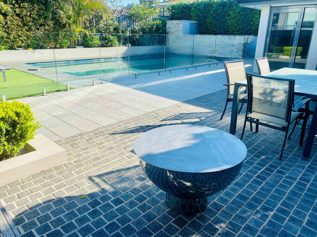 The Goblet Fire Pit – Stainless Steel next to pool