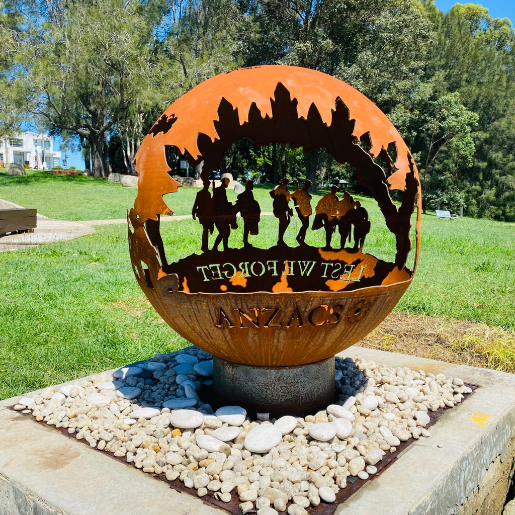 Decorative fire pit sphere with ANZACs design in a garden setting