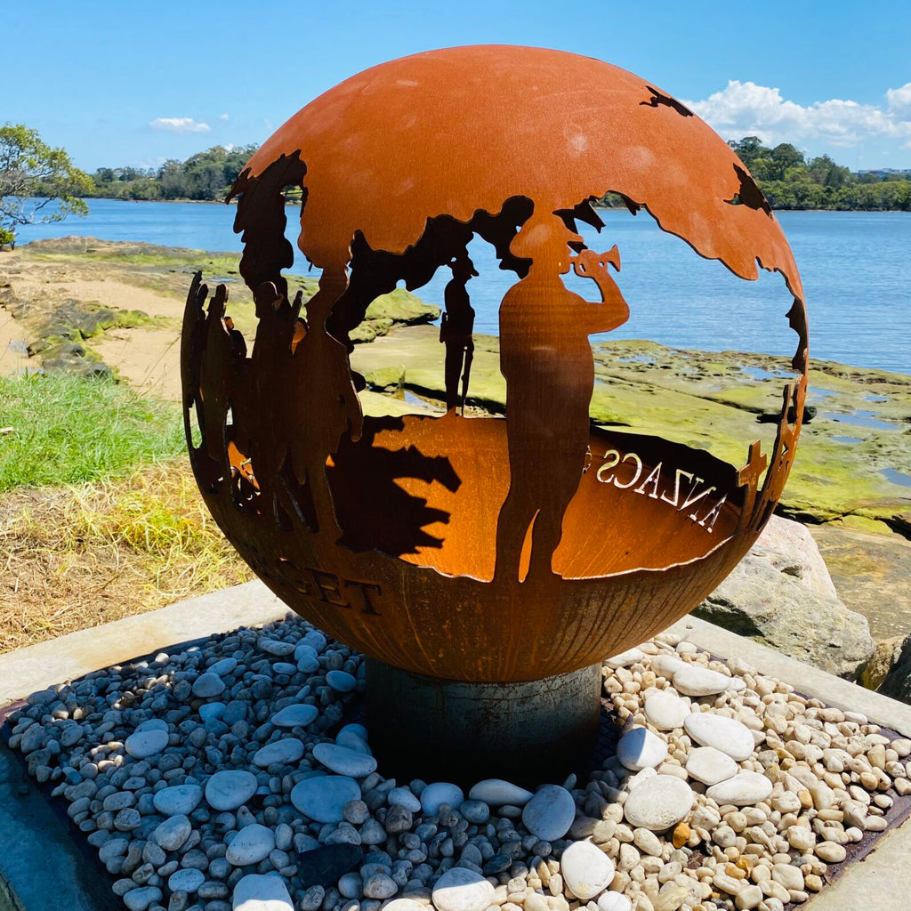 Decorative fire pit sphere with ANZACs design in a garden setting