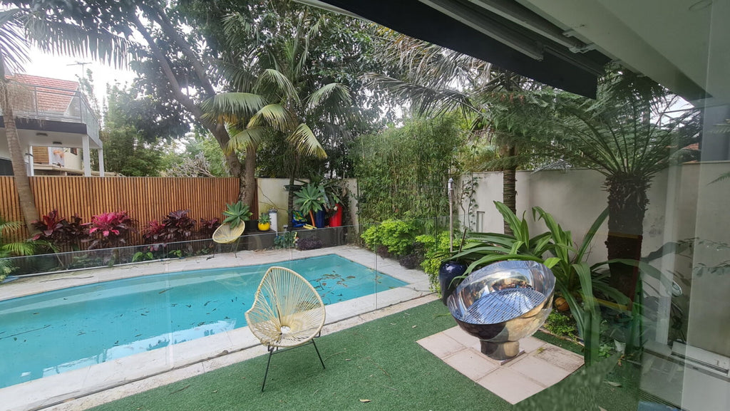 The Goblet Fire Pit – Stainless Steel next to a pool